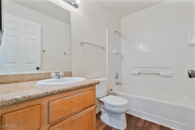 Bathroom featuring vanity, bathtub / shower combination, and dark wood finished floors