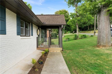 View of grassy yard featuring covered porch