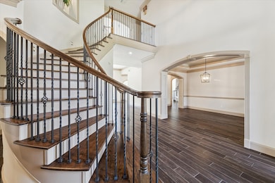 This home features 2 staircases.  Both are beautiful, wood treads and wrought iron balusters.  In this picture you can see right to the second stairway.