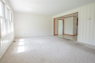 Carpeted empty room featuring visible vents, baseb