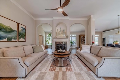 Living area with arched walkways, ceiling fan, cro