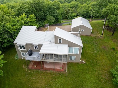 Aerial view of property and surrounding area featuring a heavily wooded area