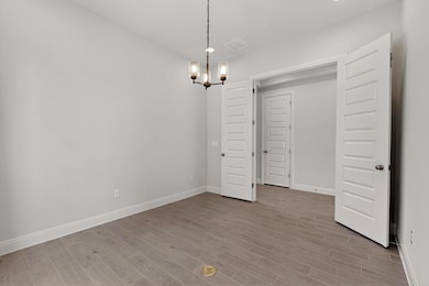 Unfurnished dining area with a chandelier and woo