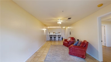 Living room featuring ceiling fan and light tile p