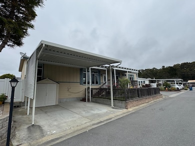 Side-by-side carport with wind screen and storage shed