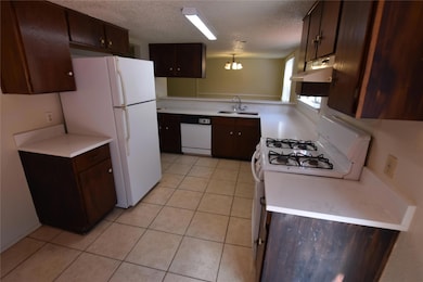 Kitchen featuring dark brown cabinets, light coun