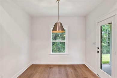 Unfurnished dining area with wood finished floors and baseboards