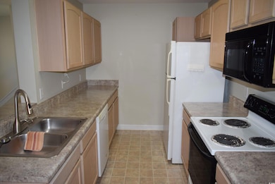 Kitchen featuring light brown cabinetry, a sink, r