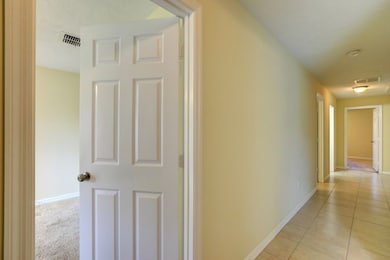 Hallway featuring baseboards and light tile patterned flooring