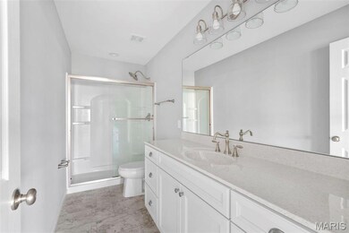 Bathroom with vanity, toilet, and a shower with door