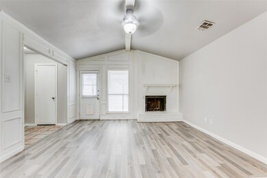 Unfurnished living room with a brick fireplace, ceiling fan, light hardwood / wood-style floors, and vaulted ceiling