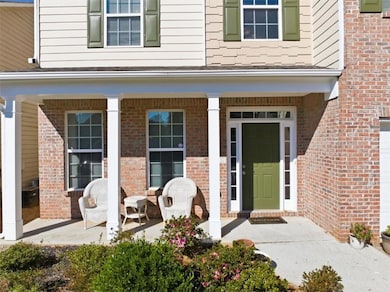 Doorway to property featuring a porch and brick siding
