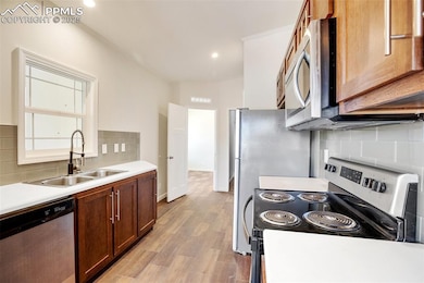 Kitchen with light countertops, a sink, tasteful b
