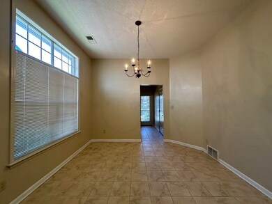Tiled spare room with an inviting chandelier and a