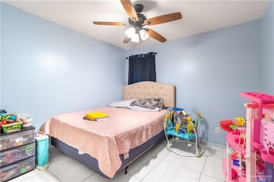 Bedroom with tile patterned floors and ceiling fan