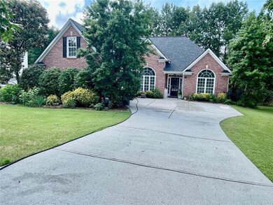 View of front of house with brick siding, a front lawn, and a shingled roof