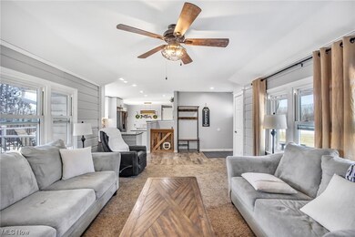Living room with ceiling fan and light colored carpet
