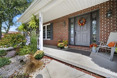Property entrance with covered porch and brick siding