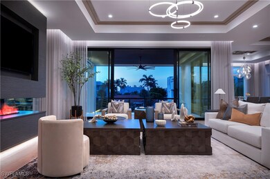 Living room with a tray ceiling, a chandelier, and