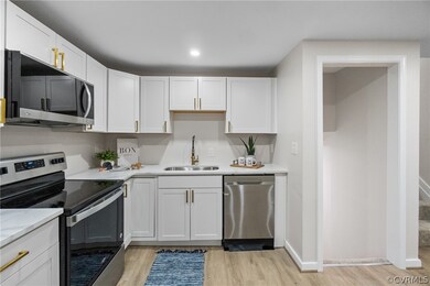 Kitchen with sink, white cabinets, light wood-type