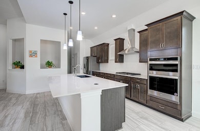 Kitchen featuring dark brown cabinetry, wall chim
