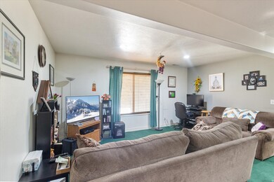 Living area featuring a desk, carpet floors, and a textured ceiling