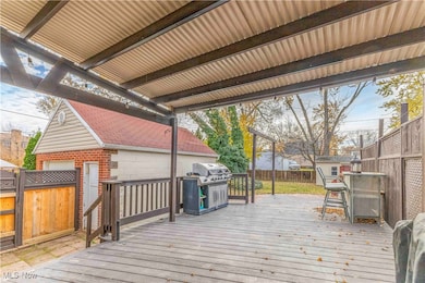 Wooden deck with a fenced backyard and a grill