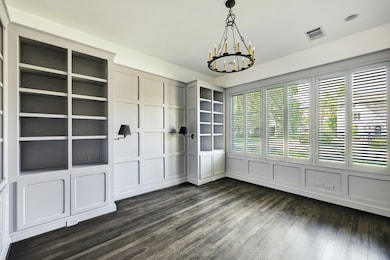 Charming paneled study with built-ins. Natural light floods the space for use as a work from home office, or even a formal living room.