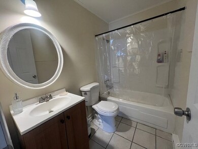 Full bathroom with toilet, tile patterned floors,