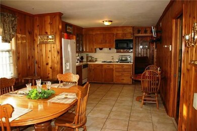 The Large Eat-In Kitchen has 2 eating areas, the original Knotty Pine Paneling and 12x12 Ceramic Tile Floor.