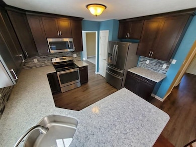 Updated Kitchen with Stainless Appliances, Corian Countertops, Soft-Close Doors and Drawers, Pantry & Breakfast Bar