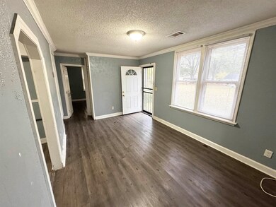 Entrance foyer featuring a textured ceiling, crown