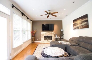 Living area, light wood finished floors, a premium fireplace, recessed lighting, and ceiling fan