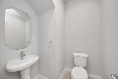 This half bathroom features a stylish pedestal sin
