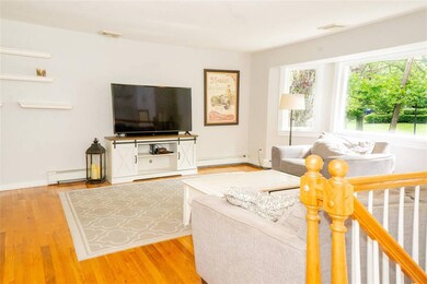 Living area featuring wood finished floors and a baseboard heating unit