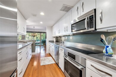 Galley kitchen with glossy white cabinets & sleek