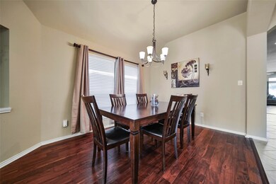 The spacious formal dining room features gleaming wood floors, an art niche, a five light chandelier and is the perfect space to enjoy a family gathering or entertain friends.