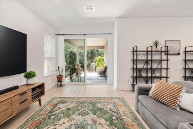 Living room with light wood-type flooring and vau