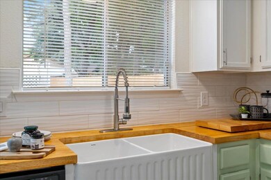 Kitchen featuring white cabinets, a sink, decorat