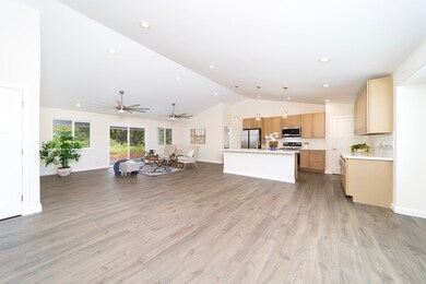 Large living room area with high volted ceilings and Lifeproof vinyl flooring.