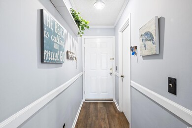 Corridor featuring a textured ceiling, crown moldi