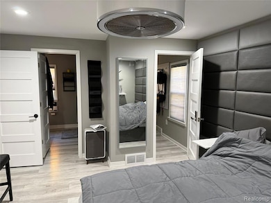 Bedroom with light wood finished floors, a closet, and recessed lighting