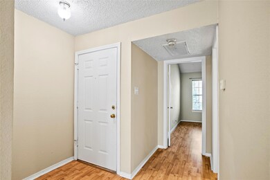 Hallway with light wood-type flooring and a textur