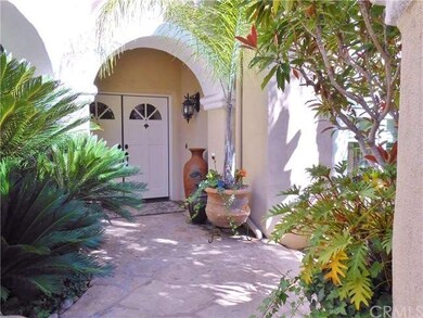 Covered Entry With Lush Plantings.