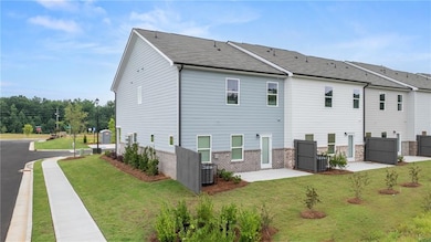 Rear view of house featuring a patio, brick siding, and a shingled roof