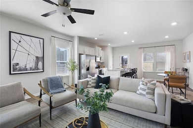 Living area featuring baseboards, light wood finished floors, recessed lighting, and a ceiling fan