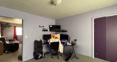 Office space with carpet and wood walls