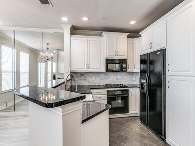 Kitchen with white cabinetry, a sink, a peninsula,