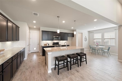 Kitchen featuring decorative backsplash, light st