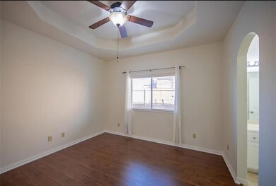 Spare room featuring ceiling fan, dark wood-type flooring, and a raised ceiling